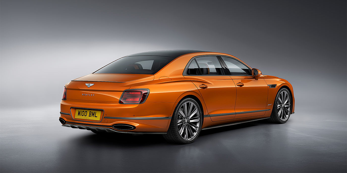 Bentley Auckland Bentley Flying Spur Speed in Orange Flame colour rear view, featuring Bentley insignia and enhanced exhaust muffler.